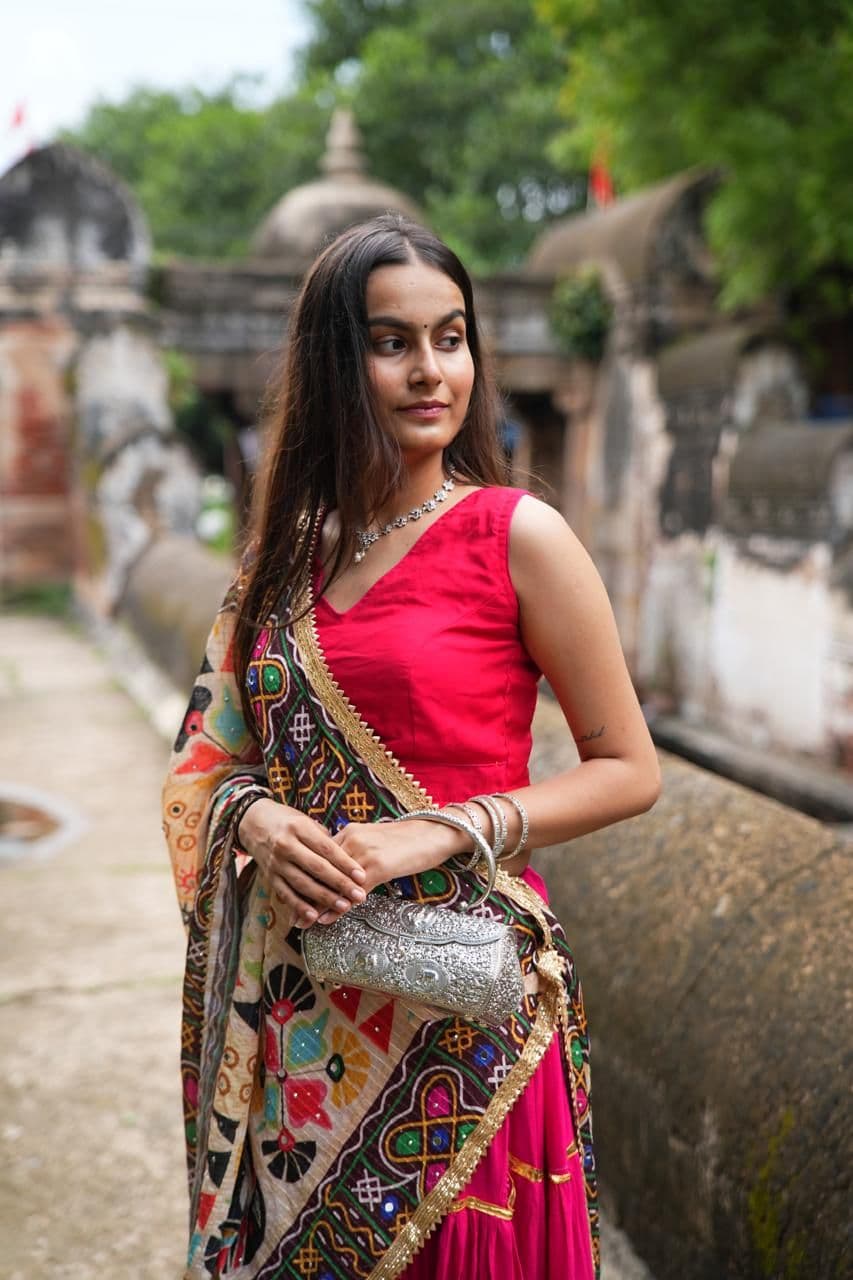Model carrying a carved silver clutch
